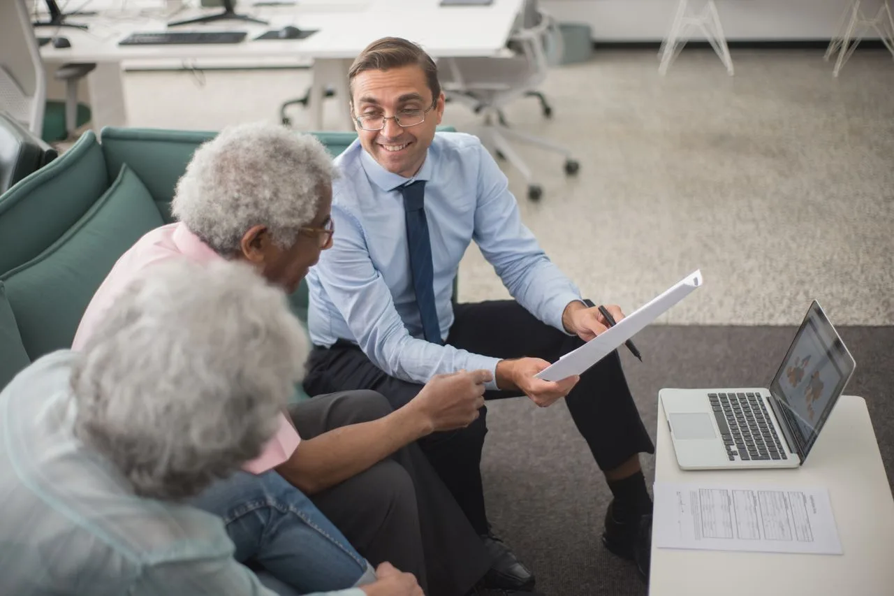 A licensed agent reviewing coverage options on paper with an older couple
