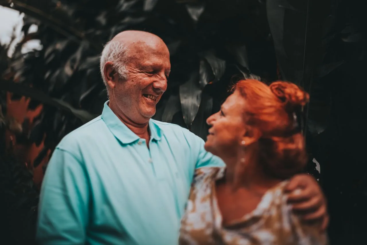 An older couple smiling together outdoors